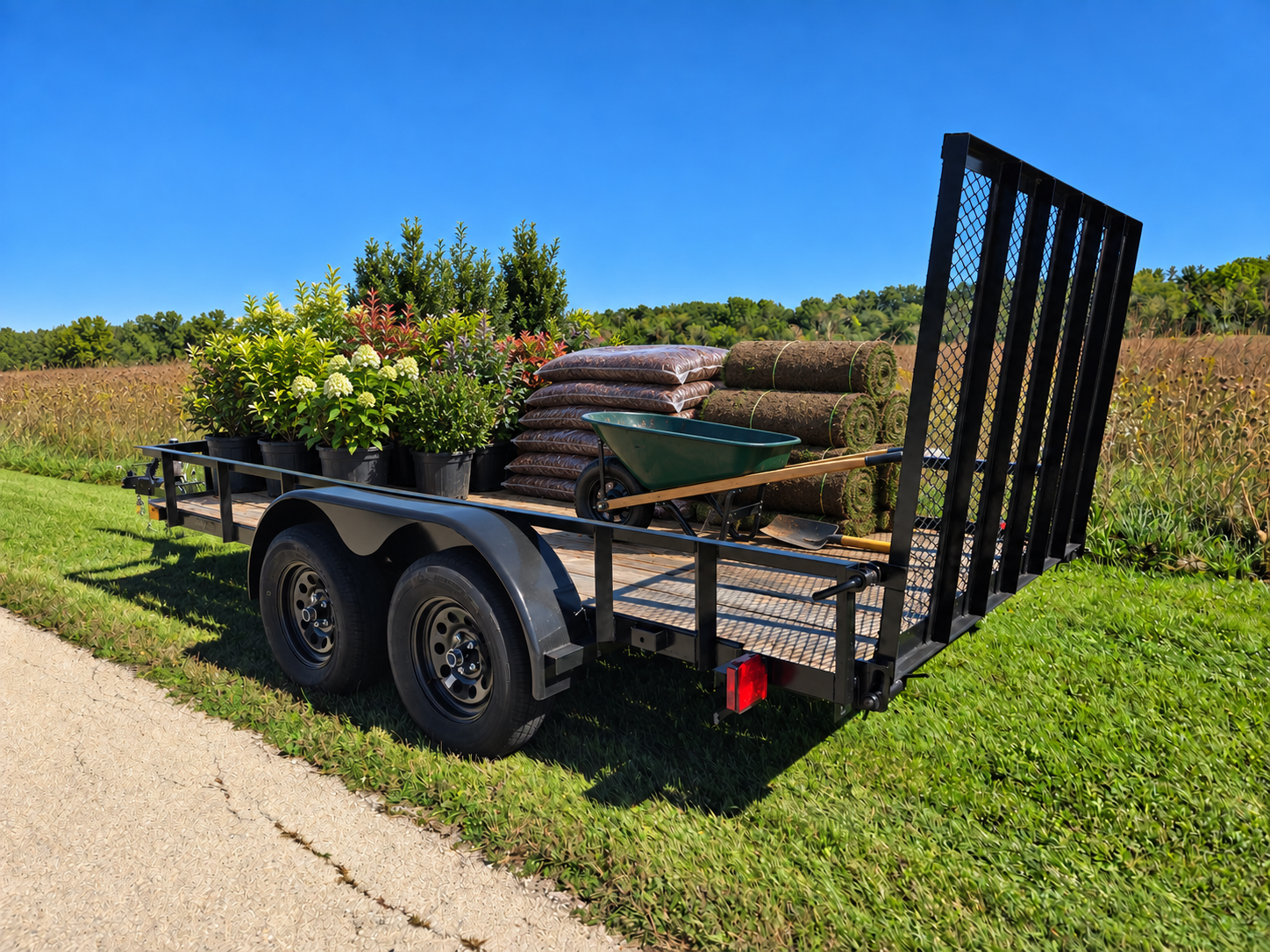 Trailer loaded with potted shrubs, bagged mulch, rolls of sod and a wheelbarrow