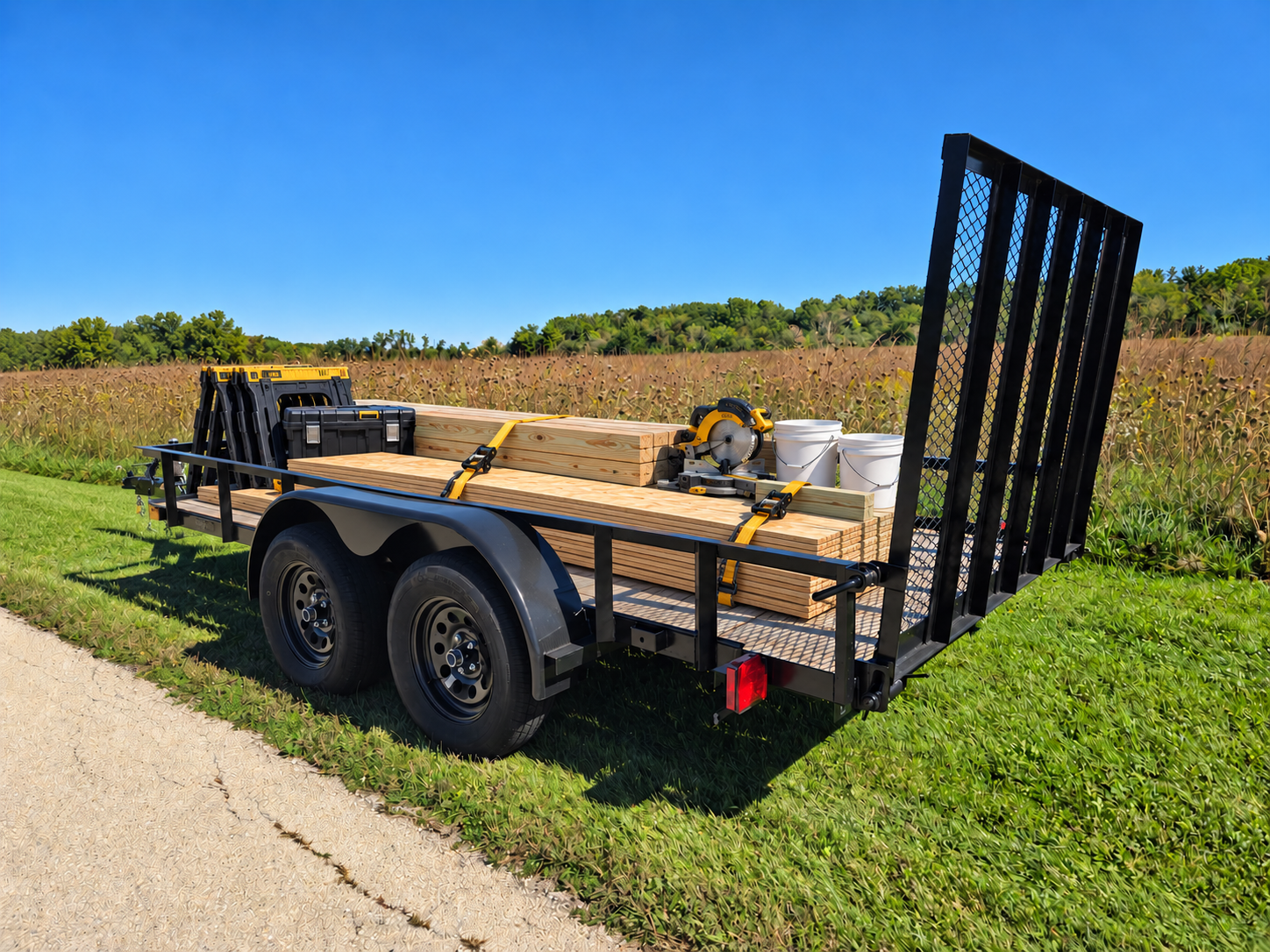 Trailer loaded with lumber, a miter saw, sawhorses, a toolbox and buckets