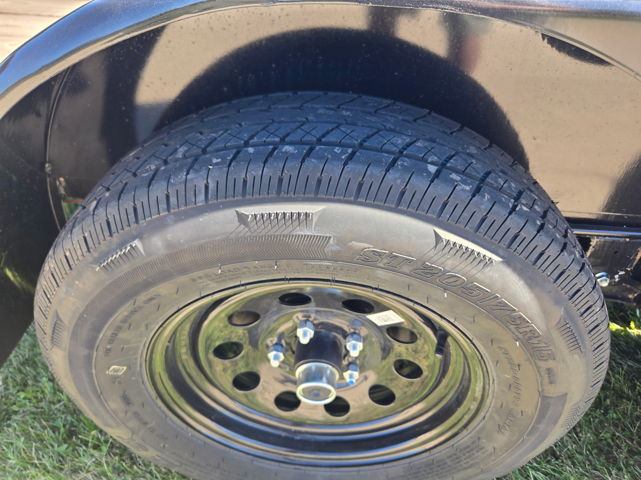 ST205/75R15 load range C trailer tire, tubeless, on a black steel wheel